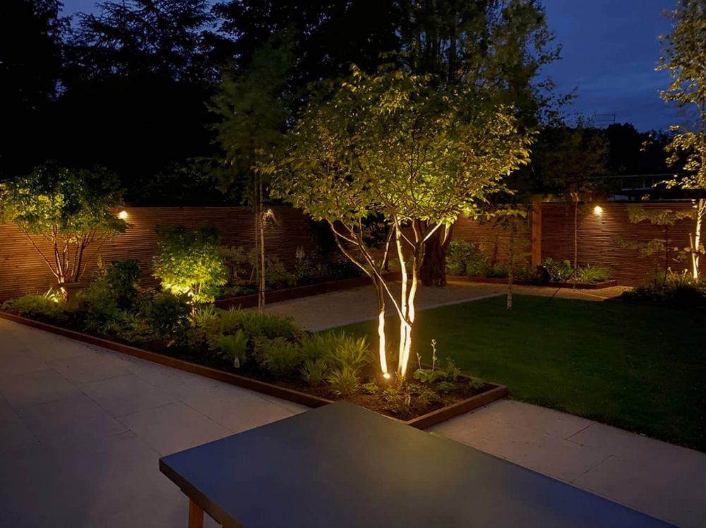 Garden lighting installed around a landscaped garden at dusk