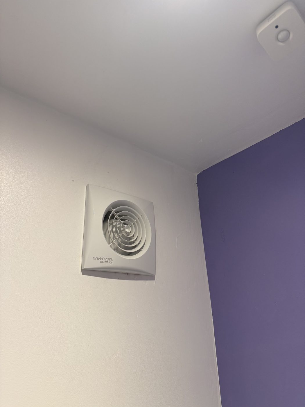A new extractor fan fitted on a bathroom wall