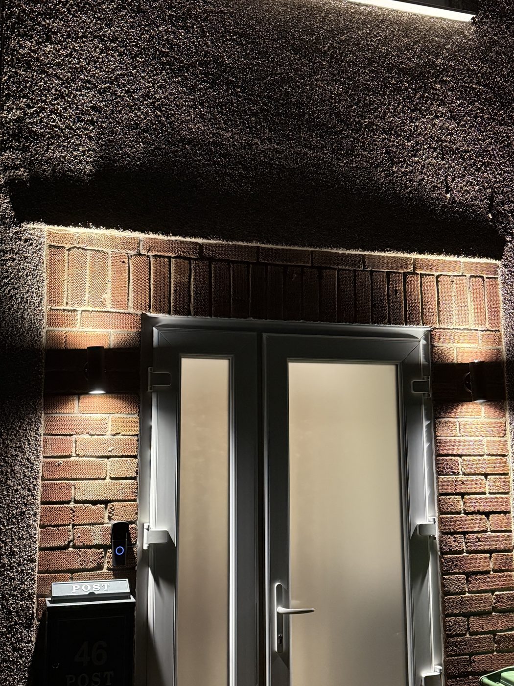 Front door wall lights lit at night