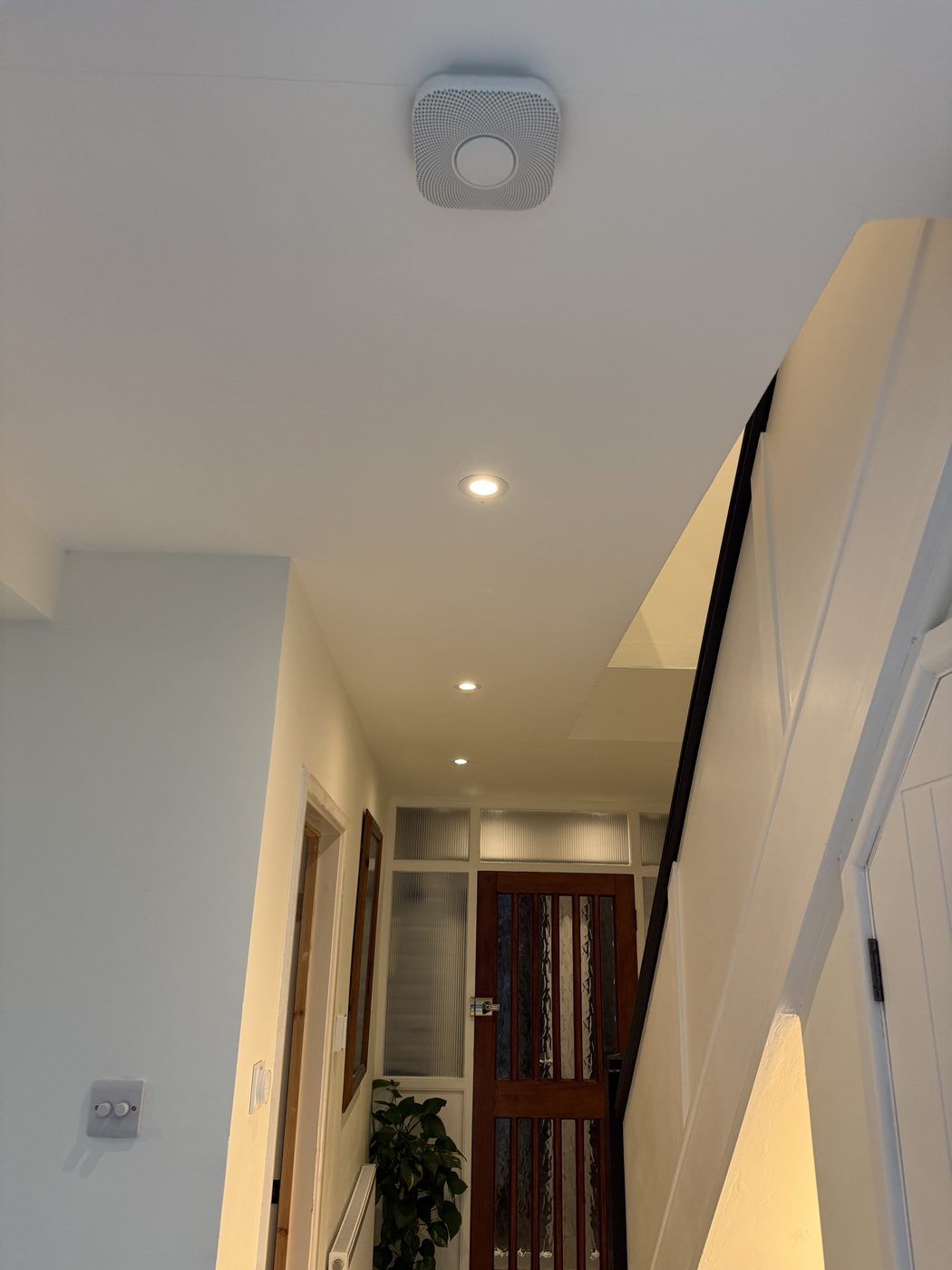 A hallway ceiling with a mains smoke alarm and downlights
